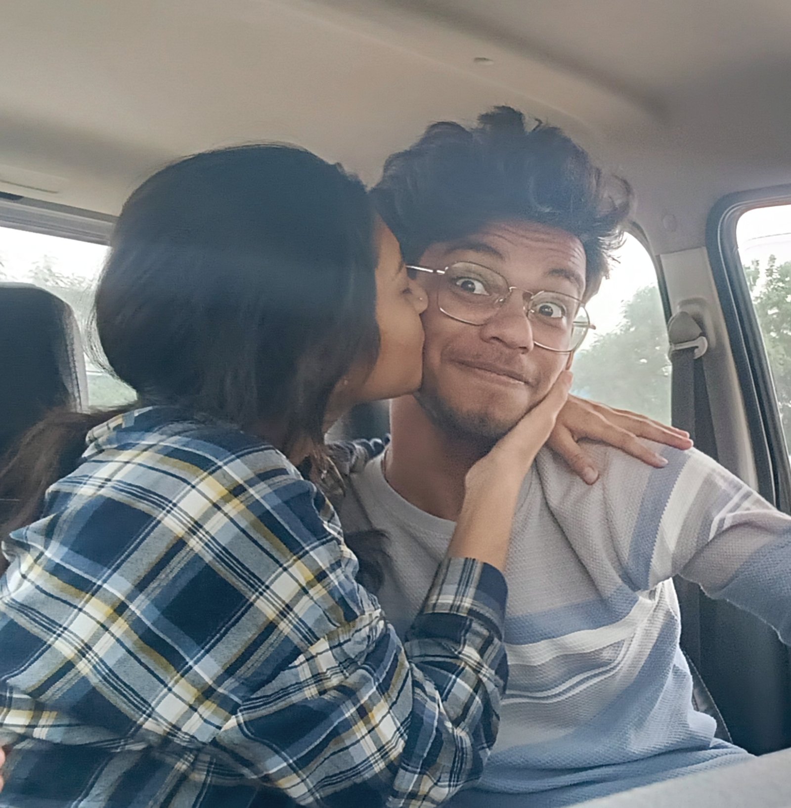 Riya kissing my cheek in a car